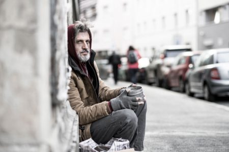 homeless man sitting on street